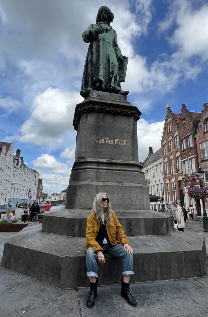 Patti Smith in Brügge, Belgien sitzt am Fuß der Jan Van Eyck Statue