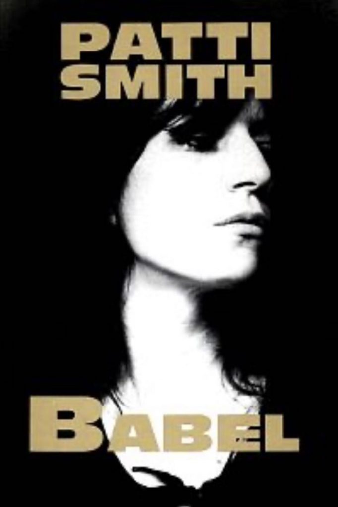 Buchcover von Patti Smith BABEL, welches 1978 veröffentlicht wurde. Es enthält ihre Gedichte, Prosa, Lyrik, Bilder und Zeichnungen. Das Foto (Lynn Goldsmith) zeigt Patti Smith im Portrait, schwarz/weiß, ihr Gesicht ist leicht zur Seite gedreht.
