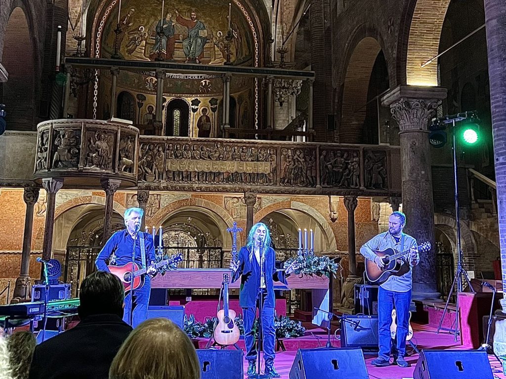Das BIld zeigt Patti Smith mit ihrem Trio während einer Performance von O HOLY NIGHT im Duomo di Modena in Italien im Dezember 2023.