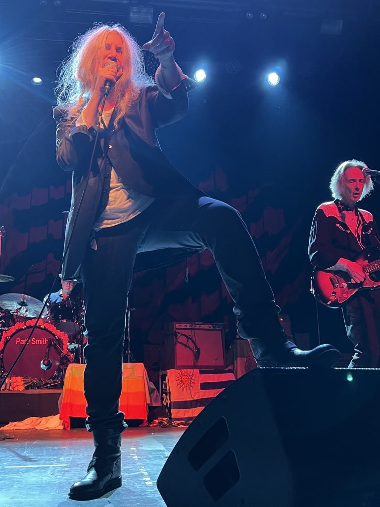 Patti Smith feiert ihren Geburtstag im Brooklyn Steel am 30. Dezember 2022. Das Bild zeigt Patti während ihrer Show auf der Bühne stehend. Sie steht am Bühnenrand, ihr linkes Bein auf einem Lautsprecher.