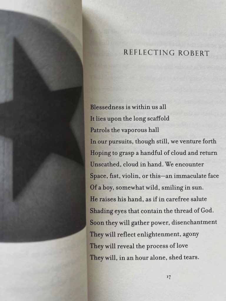Das Buch "The Coral Sea" von Patti Smith ist aufgeschlagen und zeigt auf der rechten Seite einen Auszug vom Gedicht "Reflecting Robert"
