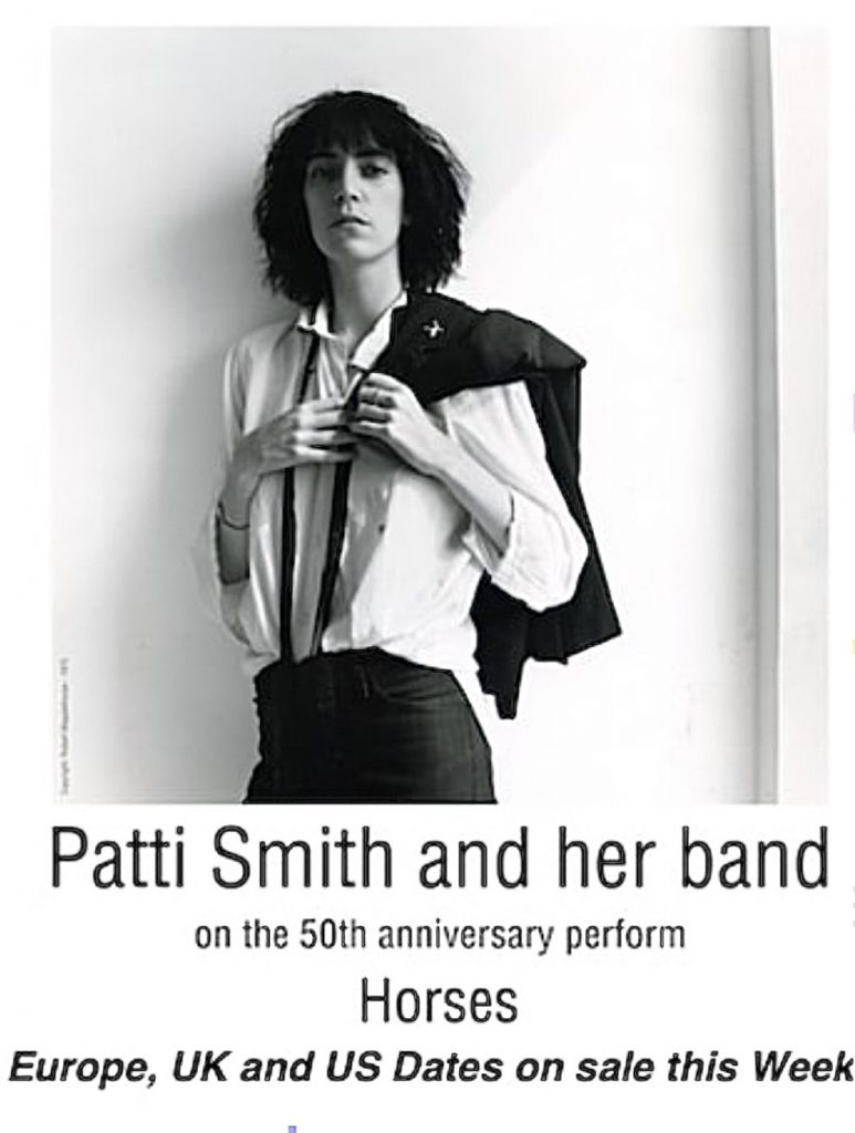 Patti Smith auf dem Plakat zur Tour 50 Jahre Horses. Das Bild von ihr ist in graustufen und zeigt sie in jungen Jahren. Sie trägt eine weiße Bluse und eine schwarze Hose mit Hosenträgern. Über ihrer linken Schulter liegt ihr Sakko, welches sie mit ihrer linken Hand festhält.